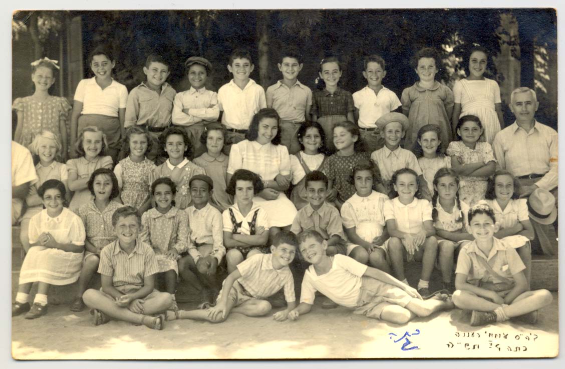 1944 תש"ה כיתה ג'2 עם המחנכת רחל בבית הספר העממי. מימין המנהל בן-ציון זיו. (מאוסף משפחת סולוביצ'יק)