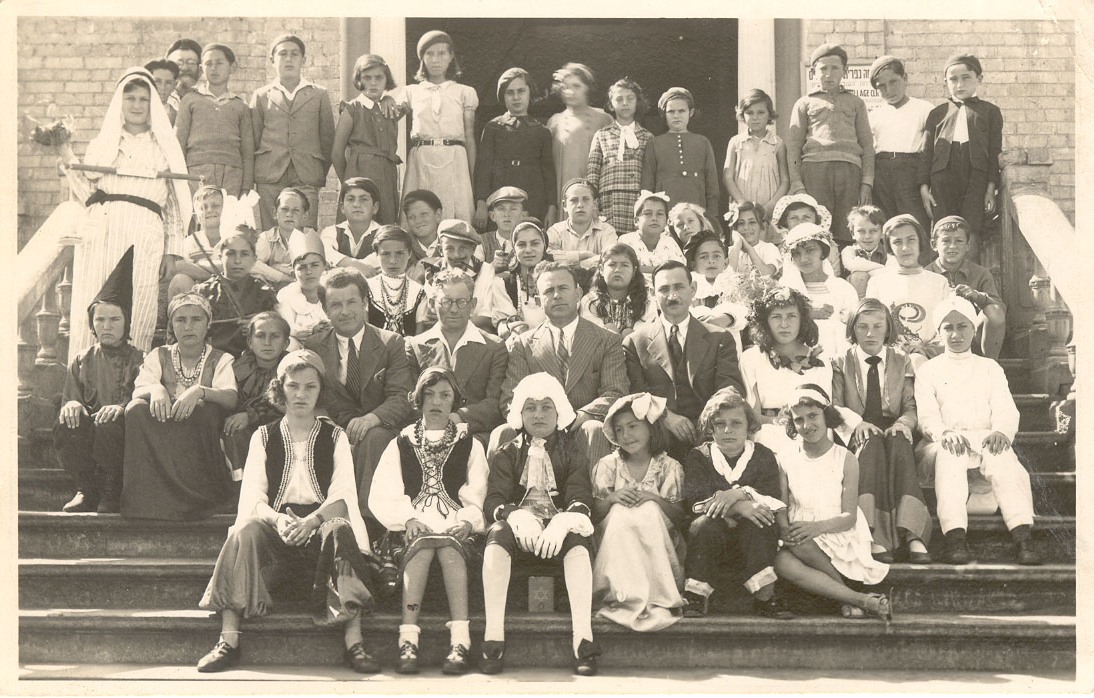פורים 1934. על מדרגות בית העם. בני אוסטרובסקי מחופש לערבי לבוש לבן משמאל